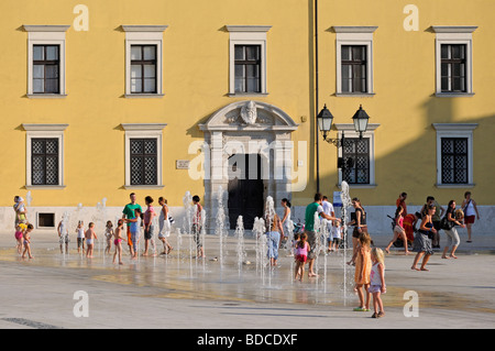 Gyor, W oltre Danubio, Ungheria. Bambini che giocano con le fontane (installato 2009) in Szechinyi ter (piazza principale) Foto Stock