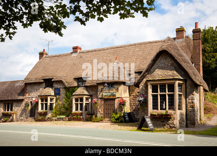 Tradizionale inglese britannico del XVI secolo con il tetto di paglia village pub travern, Wiltshire, Inghilterra, Regno Unito - il carro e cavalli Foto Stock