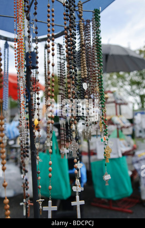 I grani del rosario appeso al di fuori di un cattolico romano souvenir shop, Knock, Irlanda Foto Stock