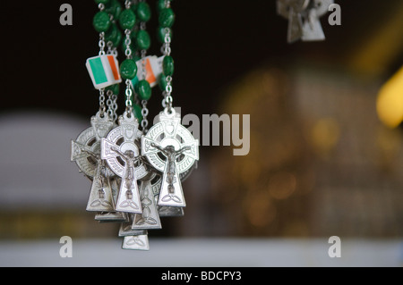 I grani del rosario appeso al di fuori di un cattolico romano souvenir shop, Knock, Irlanda con bandiere irlandese Foto Stock