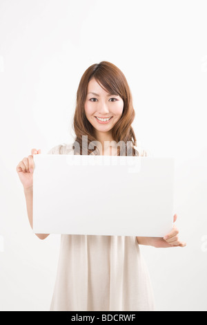 Giovane donna tenendo la bacheca Foto Stock
