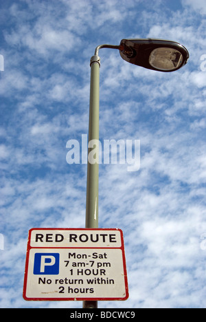 British cartello stradale che indica una Londra percorso rosso e dando parcheggio dettagli della restrizione, in East Sheen, a sud-ovest di Londra - Inghilterra Foto Stock