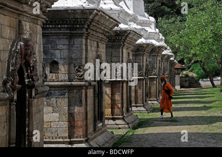 Sadhu hindu hindi santo uomo a camminare tra edicole votive Chaityas tempio di Pashupatinath valle di Kathmandu in Nepal Foto Stock