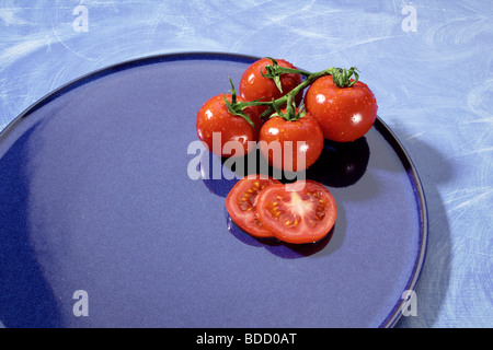 Pomodori a grappolo sulla piastra blu Foto Stock