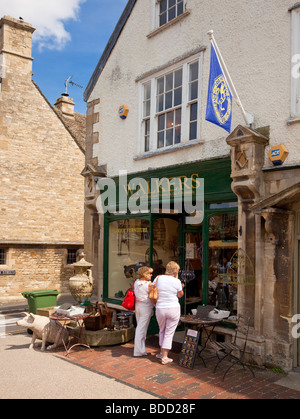 Window shopping in un piccolo negozio di antiquariato in Cotswolds città di Burford, Oxfordshire, England, Regno Unito Foto Stock