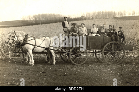 Otto lavoratori nel cavallo fattoria carro Foto Stock