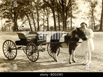 Piccola ragazza ricca con Pony carrello Foto Stock