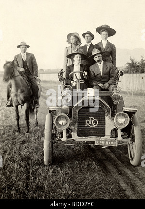 Cinque persone in antiche Reo Auto & uomo a cavallo Foto Stock