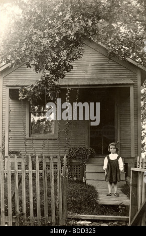 Bambina di fronte ai suoi Cottage Foto Stock