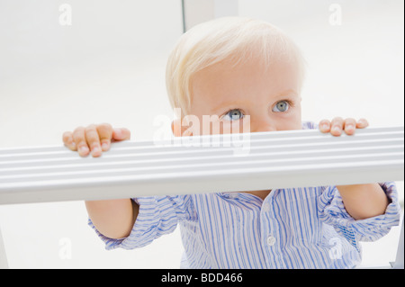 Baby boy con una scala a pioli Foto Stock