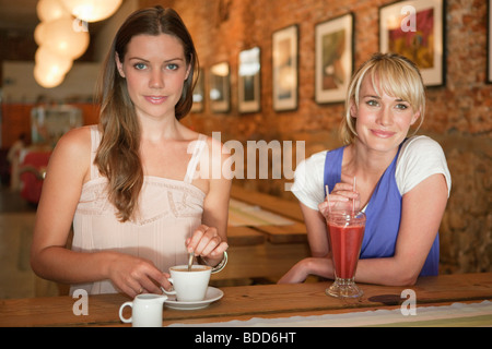 Due donne aventi le bevande in un cafe Foto Stock