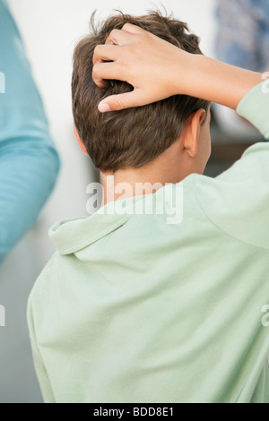 Ragazzo di graffiare la sua testa Foto Stock