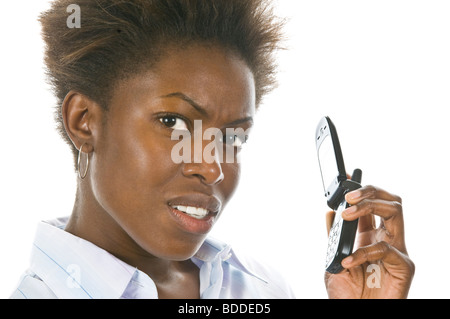 Studio ritratto di una giovane attraente arrabbiato African business donna su un telefono mobile contro un bianco puro (255) dello sfondo. Foto Stock