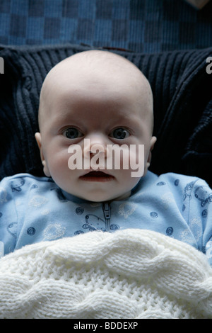 A quattro mesi di età bambino in un sonno suit utilizzando la mamma il ponticello come una coperta e papà della ponticello come un cuscino. Modello rilasciato Foto Stock