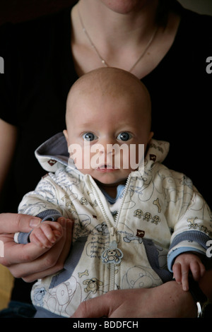 A tre mesi il bambino seduto e giocare con la sua mamma in una camicia. Modello rilasciato Foto Stock