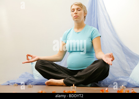 Donna incinta esercizio di yoga Foto Stock