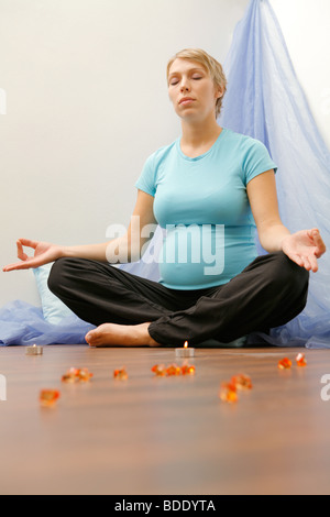 Donna incinta esercizio di yoga Foto Stock