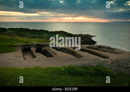 Tombe in pietra, St Patricks cappella, testa di Heysham, Lancashire al tramonto Foto Stock