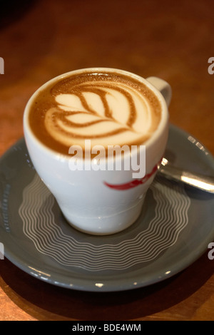 Schiuma artistica in un doppio espresso. Dettaglio primo piano motivo floreale messa a fuoco selettiva. Foto Stock