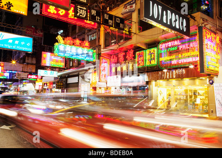 Insegne al neon e car light trail in Tsim Sha Tsui, Kowloon, Hong Kong, Cina. Foto Stock