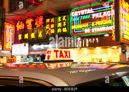 Insegne al neon e taxi luce in Tsim Sha Tsui, Kowloon, Hong Kong, Cina. Foto Stock