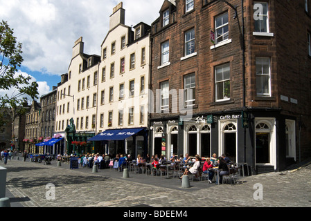 Il Grassmarket nel centro storico di Edimburgo in una giornata di sole con i visitatori all'aperto godendo di Mangiare & bere a diversi ristoranti Foto Stock