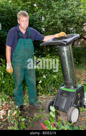 Di mezza età lavoratore forestale con trinciatrice Foto Stock