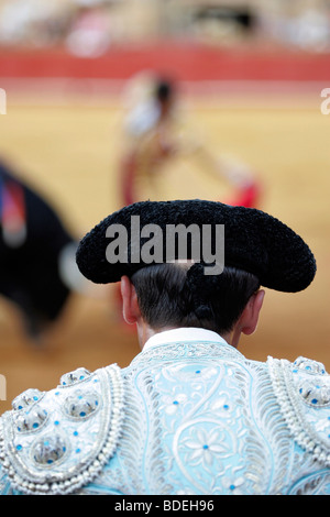 Torero assistente guardando il suo capo le prestazioni. La corrida al Real Maestranza bullring, Siviglia, Spagna, 15 agosto 2006. Foto Stock