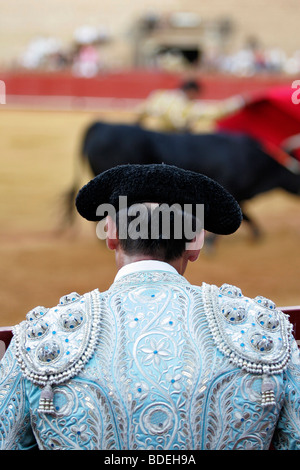 Torero assistente guardando il suo capo le prestazioni. La corrida al Real Maestranza bullring, Siviglia, Spagna, 15 agosto 2006. Foto Stock