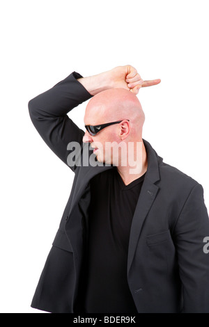 Testa calva Uomo con occhiali da sole puntando con il suo dito indice a indietro Foto Stock