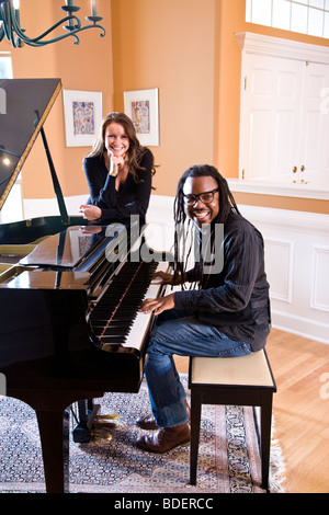 African American uomo suonare il pianoforte con la femmina amico ascolto Foto Stock