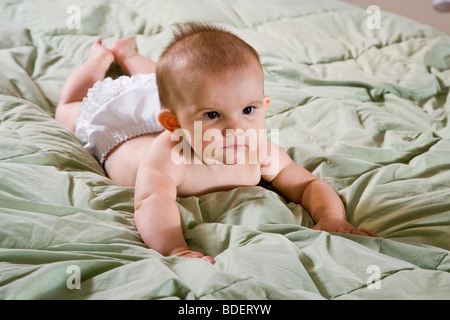 Sei mesi il bambino giacente sul letto piumino Foto Stock