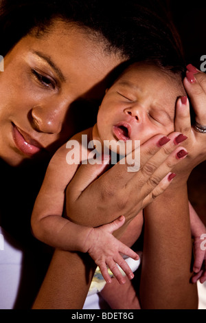 Afro-americano di madre holding neonato Foto Stock