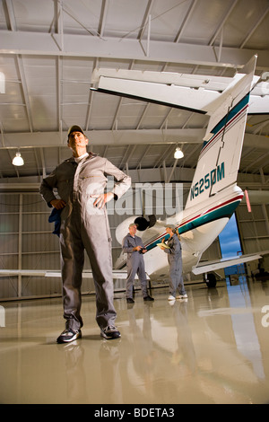 Tre aereo meccanica in hangar Foto Stock