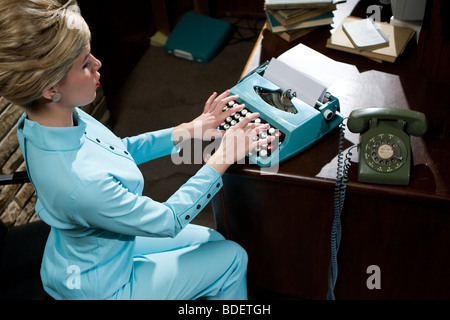 Vintage Ritratto di giovane segretario con arnia digitando al desk Foto Stock