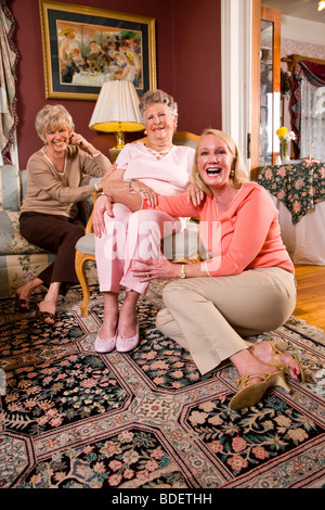 Donna anziana a casa con le figlie adulte Foto Stock