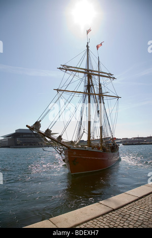 Il 35 m topsail schooner 'Lilla Dan' di lasciare il porto di Copenhagen, Danimarca, con la Royal Opera House in background. Foto Stock