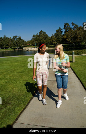 Ispanico e Caucasico appendere fuori due mix razziali razziale mixed ragazze passeggiate nel parco. Signor Foto Stock