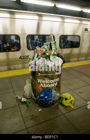 Un cestino traboccante di lattine di birra e bottiglie raccolte da Metro North auto pulitori è visto in Grand Central Terminal Foto Stock