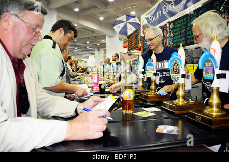 Camra membri tick off e ordinare e gustare birre alla spina presso il Great British Beer Festival che si tiene annualmente a London Earls Court. Foto Stock