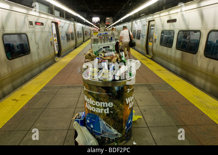 Un cestino traboccante di lattine di birra e bottiglie raccolte da Metro North auto pulitori è visto in Grand Central Terminal Foto Stock