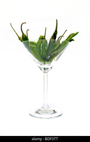 Studio Immagine di peperoncini verdi in bicchiere da cocktail preso contro uno sfondo bianco Foto Stock