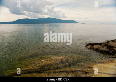 Bella Orcas Island può essere visto attraverso lo Stretto di Rosario, da una spiaggia sul lato ovest di Lummi Island, Washington, Stati Uniti d'America. Foto Stock