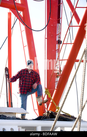 Giovane pescatore in plaid shirt su barca da pesca Foto Stock