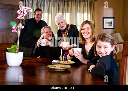 Multi-generazionale famiglia nella sala da pranzo con snack Foto Stock