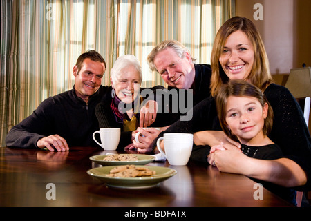 Multi-generazionale famiglia nella sala da pranzo con snack Foto Stock