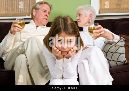 Coppia senior rilassante sul divano con bicchieri di vino, annoiato ragazza in centro Foto Stock