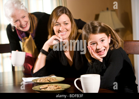 Multi-generazionale famiglia seduti nella sala da pranzo con snack Foto Stock