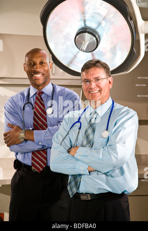 Ritratto di multi-etnico medici nella stanza di ospedale con luci chirurgico Foto Stock
