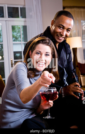 Multi-etnico giovane avente un drink insieme nei moderni loft Foto Stock